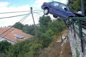 A crashed car on a bridge railing