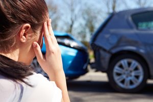 Stressed Driver Sitting At Roadside After Traffic Accident